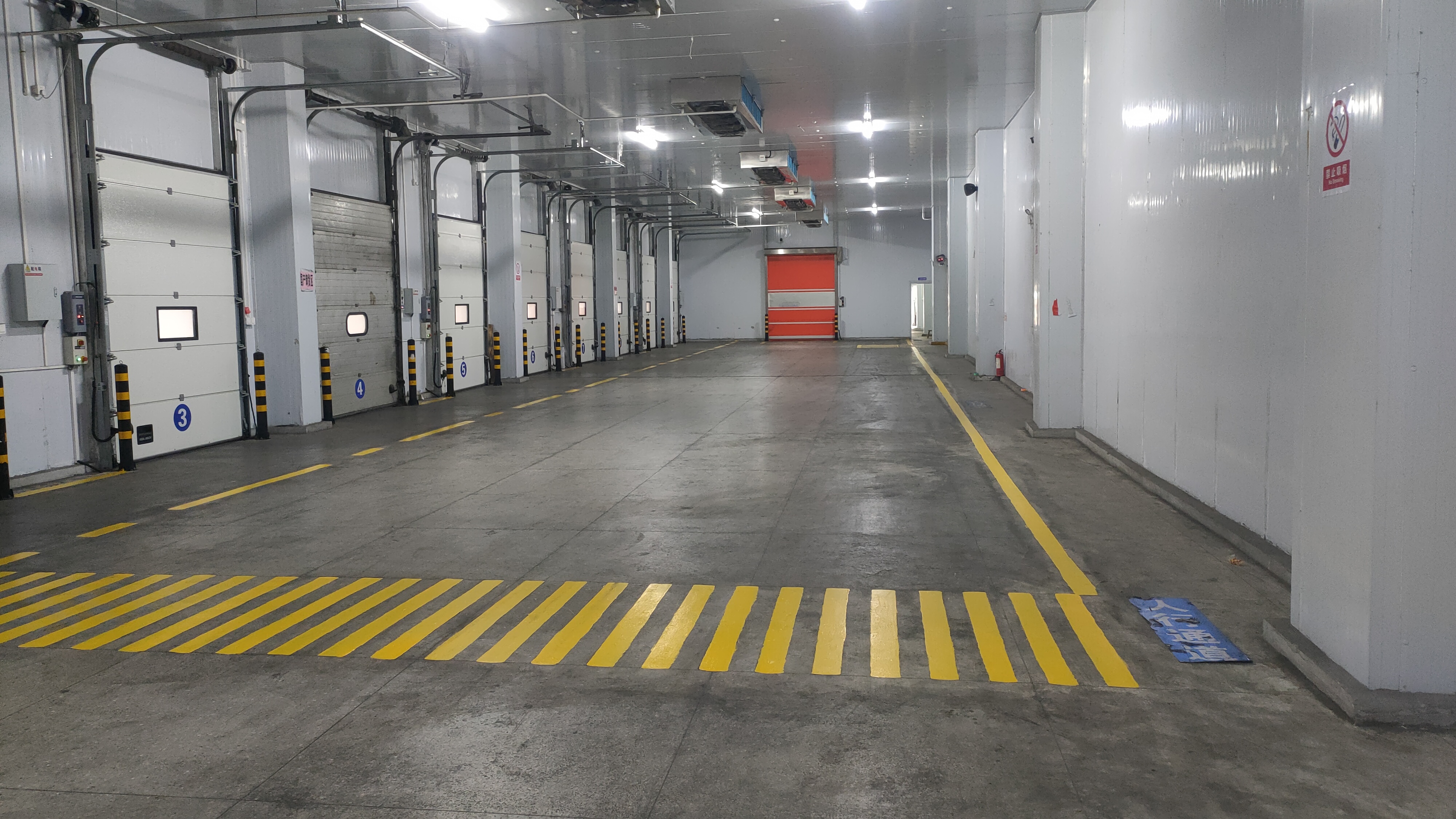 Bay corridor at the Baixian Strait Logistics Center — pedestrian crossing markings, multi-bay configuration.