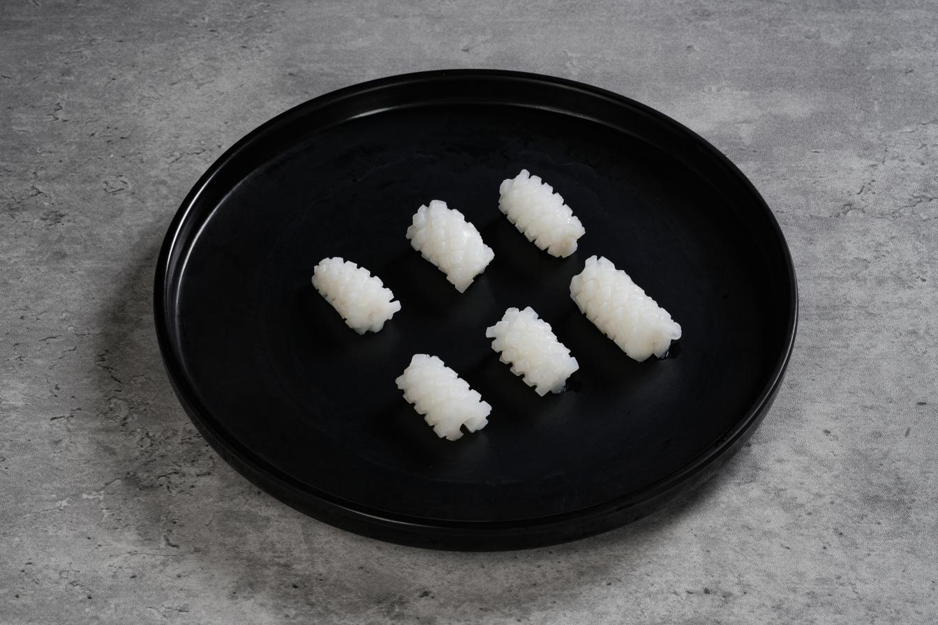 Illex Squid Carved — pattern-cut mantle pieces presented on a black plate